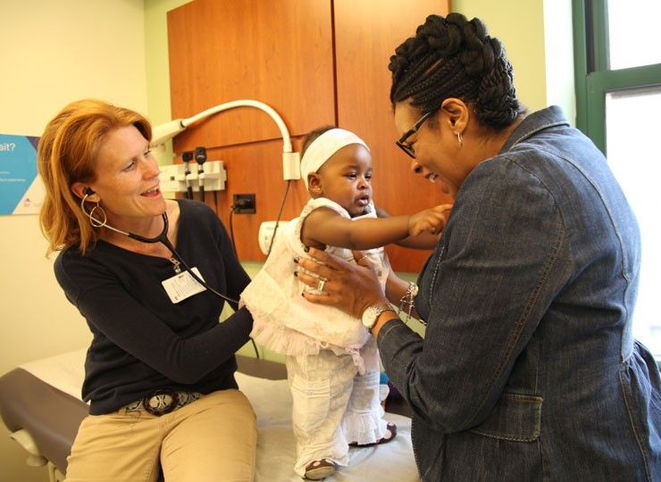 Photo of Doctor and parent with pediatric patient